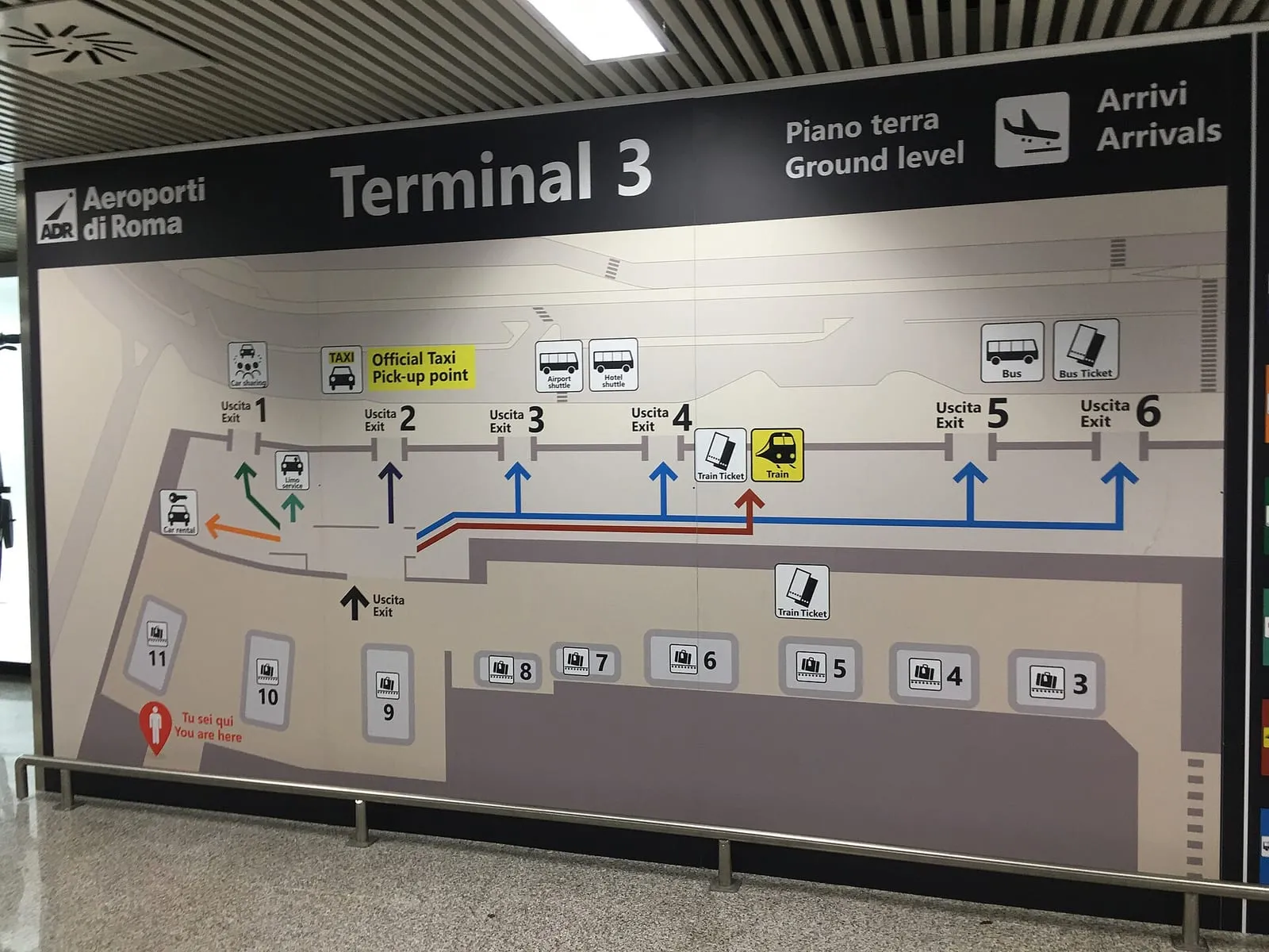 Panneau d'information du terminal 3 de l'aéroport de Fiumicino, avec les points de départ des taxis et la billetterie du train