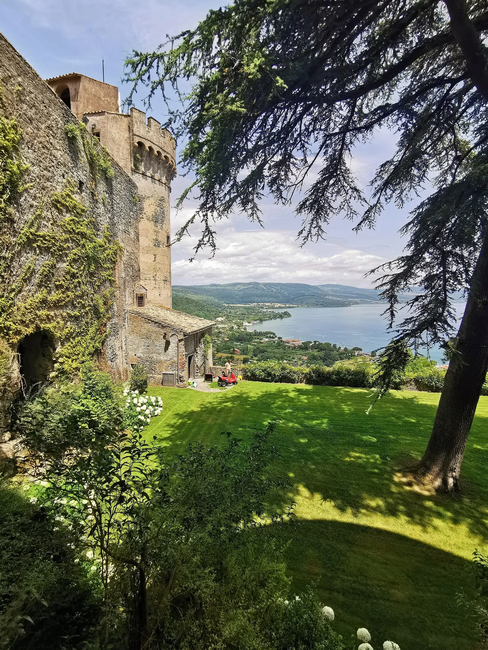 La tour du château Orsini-Odescalchi de Bracciano, sa pelouse et le lac de Bracciano en contrebas
