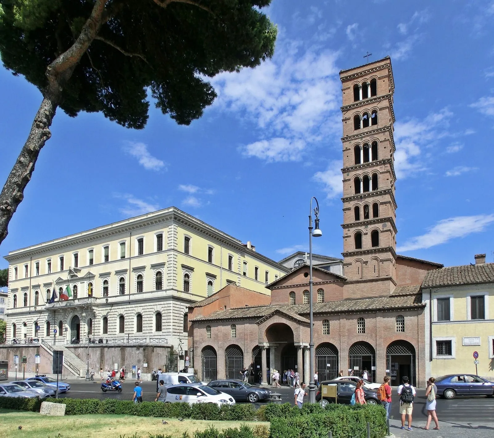 La basilique Santa Maria in Cosmedin vue de la piazza : le portique à arcades, la façade médiévale et le clocher roman à sept étages qui domine les toits