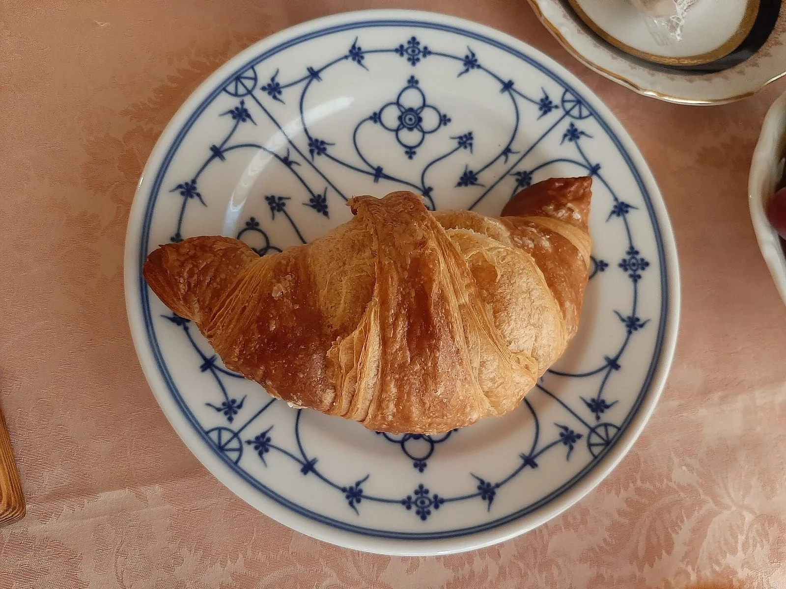 Cornetto servi au petit déjeuner d'un B&B italien, posé sur une assiette avec sa boisson chaude
