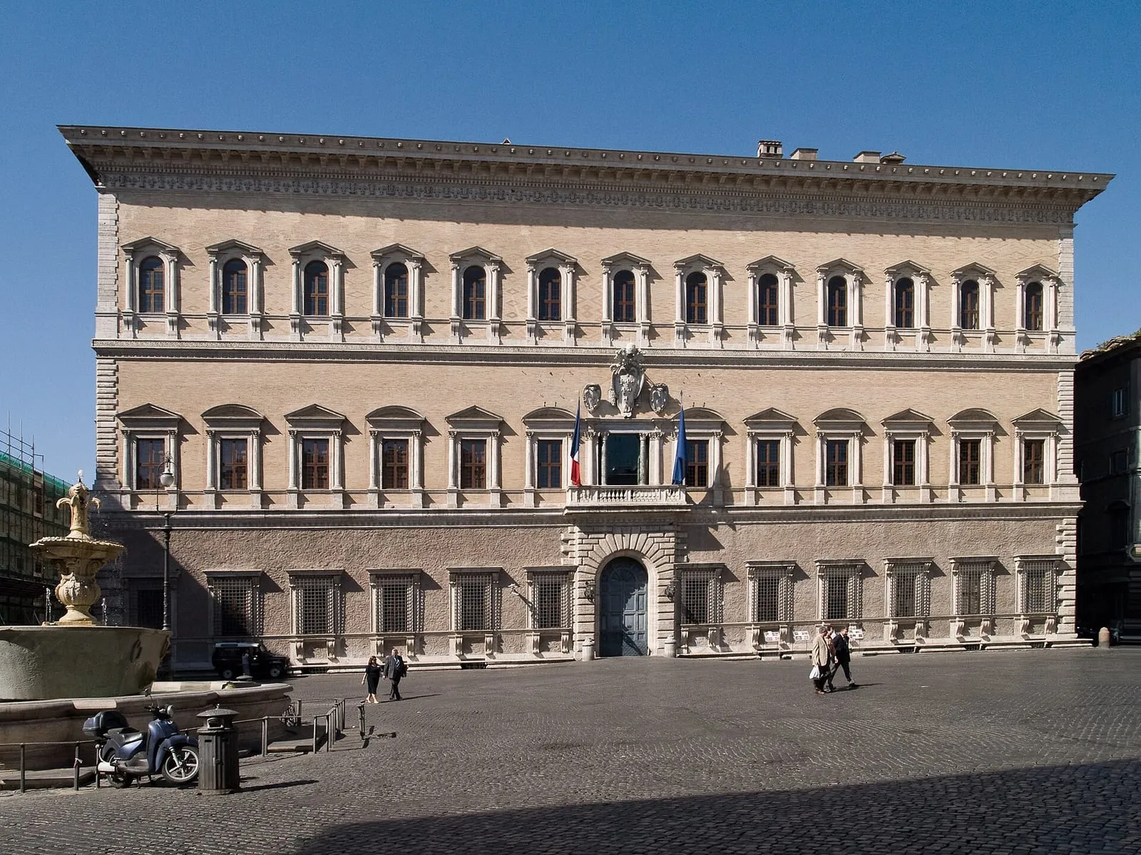 La façade du palais Farnese sur la piazza Farnese à Rome, avec les drapeaux italien et européen et une fontaine de granit au premier plan