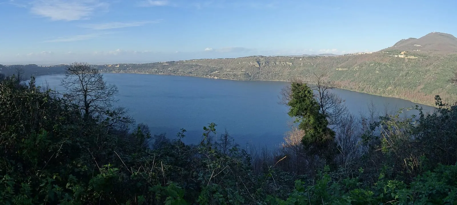 Vue plongeante sur le lac Albano, son eau calme et les reliefs boisés du cratère