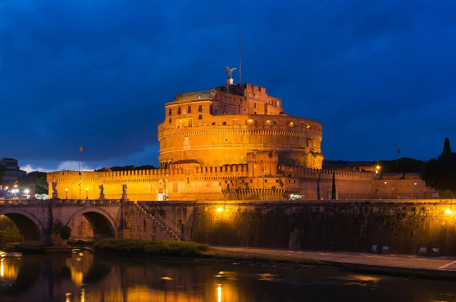 Le château Saint-Ange et le pont Saint-Ange au crépuscule, vus depuis les quais du Tibre à Rome