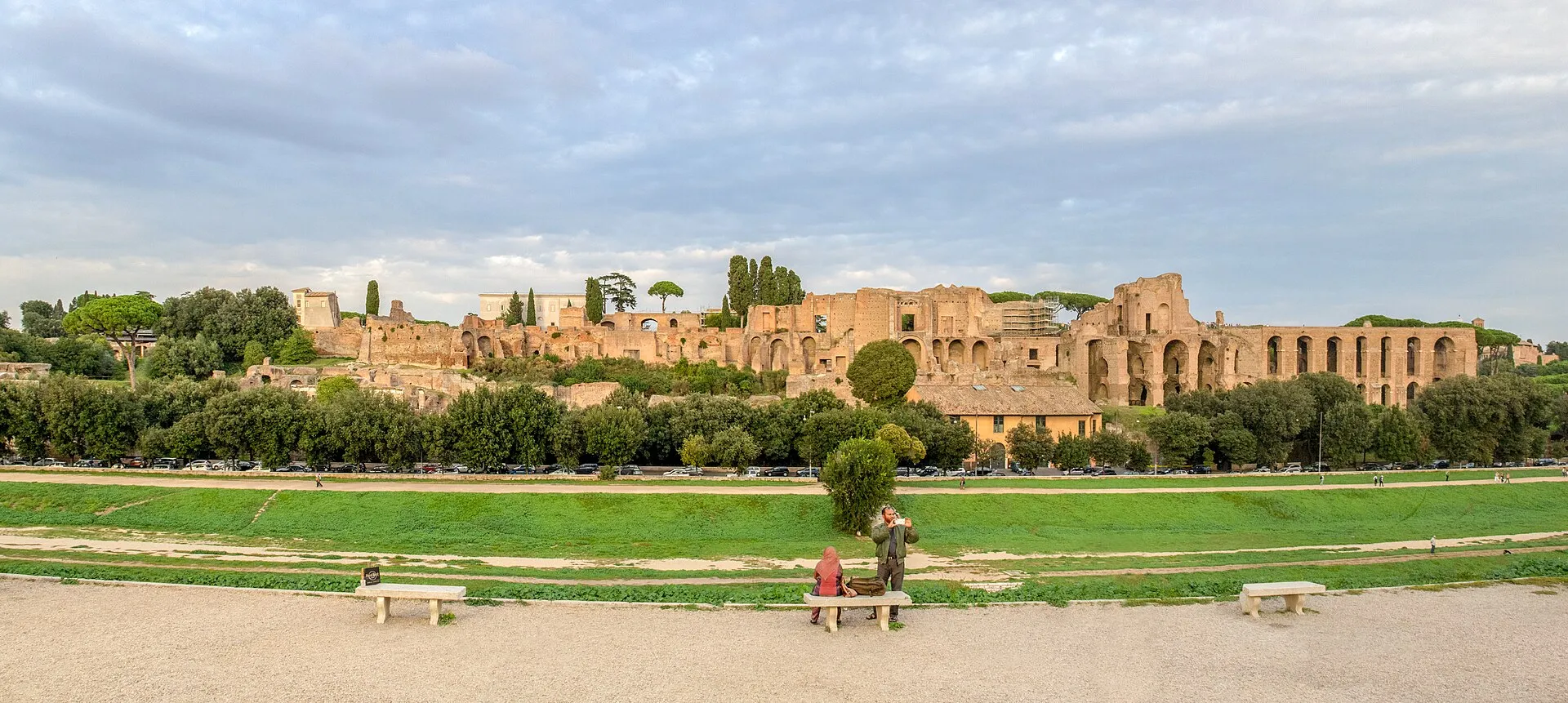 Vue du Circus Maximus à Rome : l'immense esplanade gazonnée de la vallée de la Murcia au premier plan, avec le Palatin et ses ruines en arrière-plan