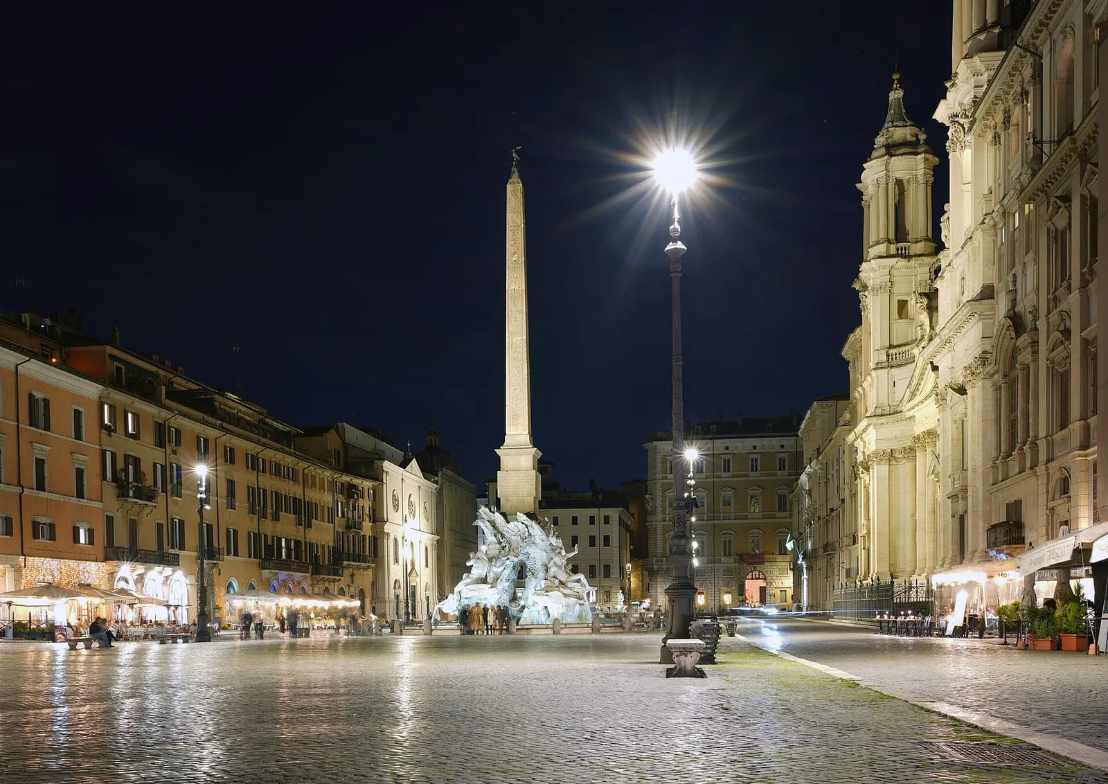 La piazza Navona à Rome de nuit, sa fontaine des Quatre Fleuves et son obélisque éclairés