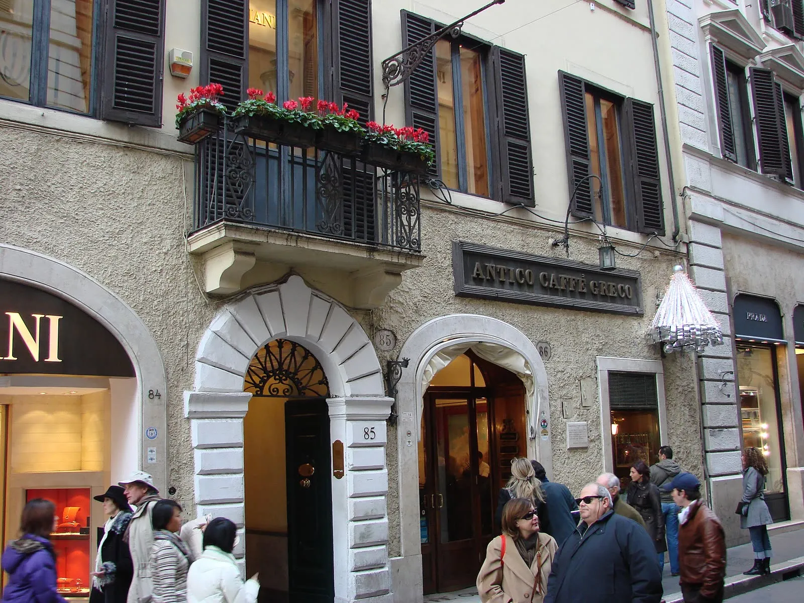 La façade de l’Antico Caffè Greco, via dei Condotti à Rome, devant laquelle passent des piétons en manteau