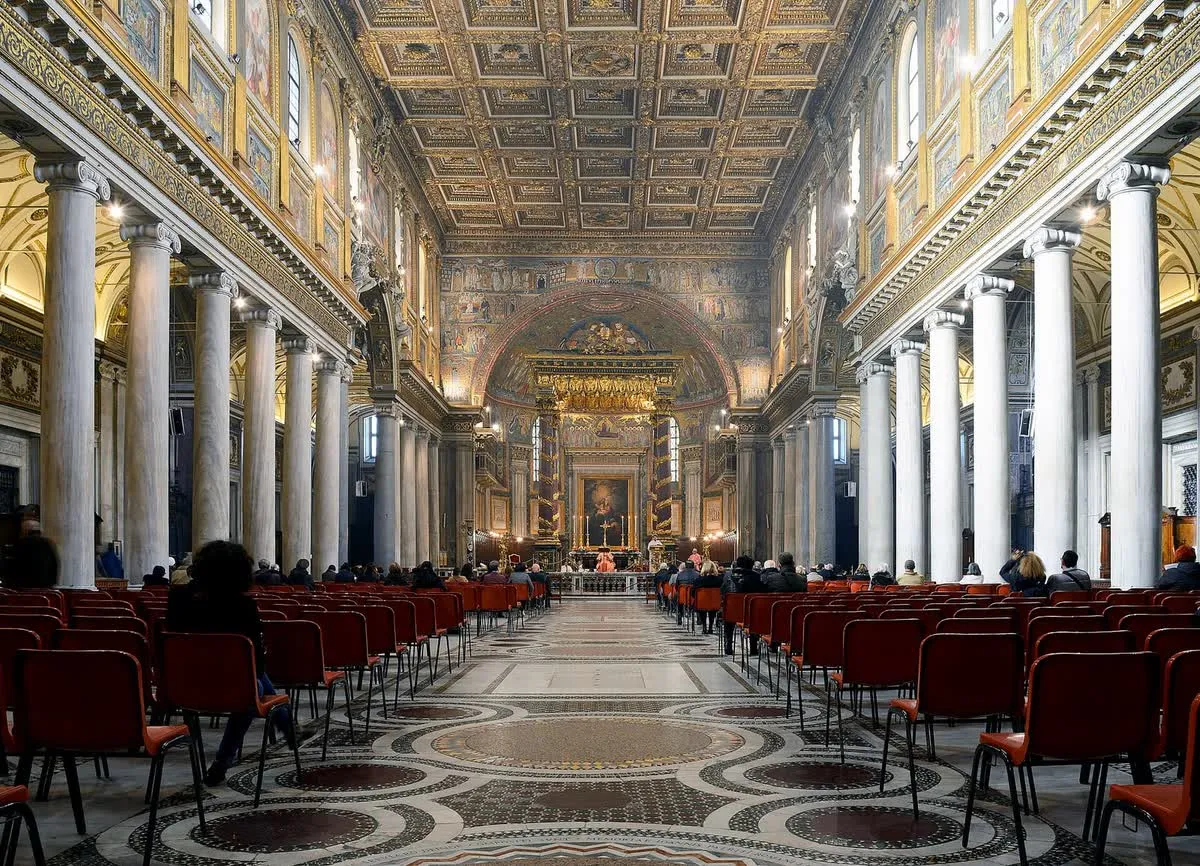 La nef de Sainte-Marie-Majeure à Rome, avec son plafond à caissons dorés, ses longues colonnes de marbre et son pavement cosmatesque