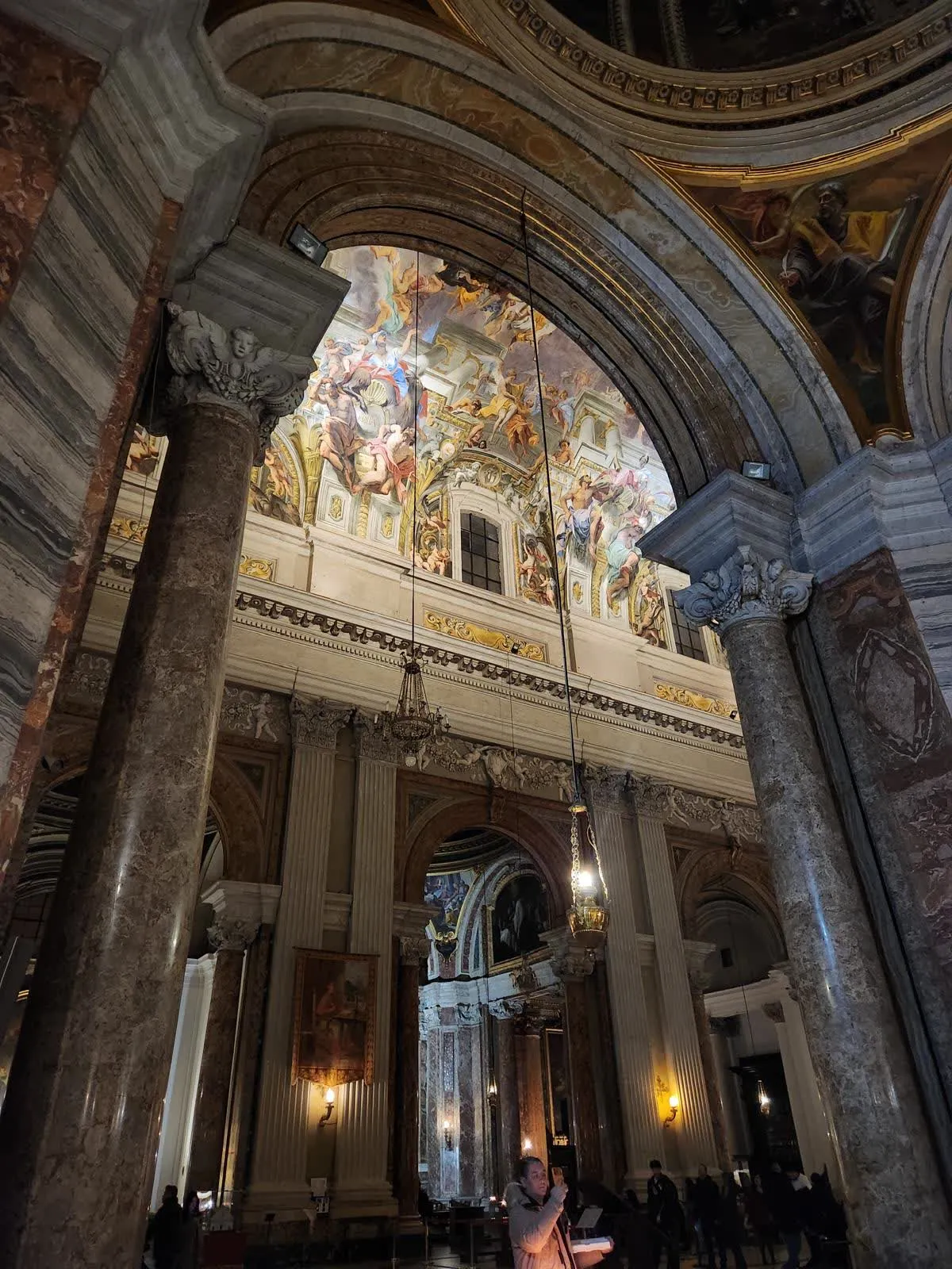 La voûte peinte en trompe-l’œil de l’église Sant’Ignazio à Rome, vue depuis la nef sous les arcs et les colonnes de marbre