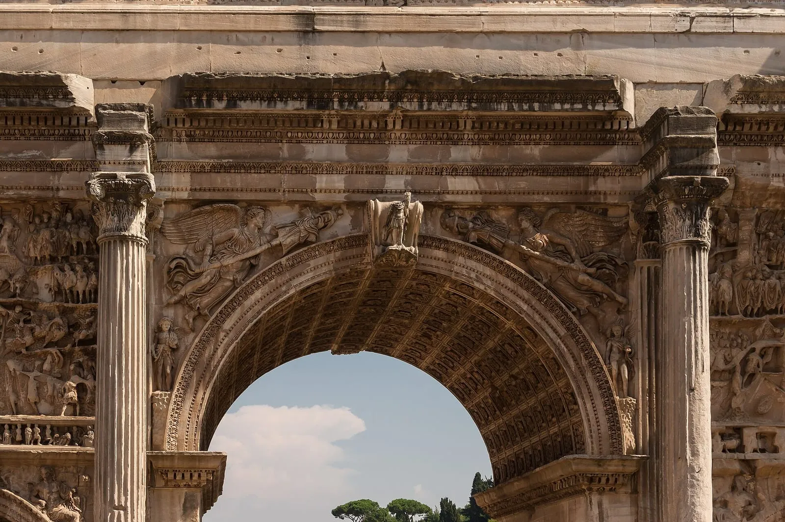 Détail de l'arche centrale de l'arc de Septime Sévère au Forum romain, encadrée de colonnes corinthiennes et ornée de Victoires ailées