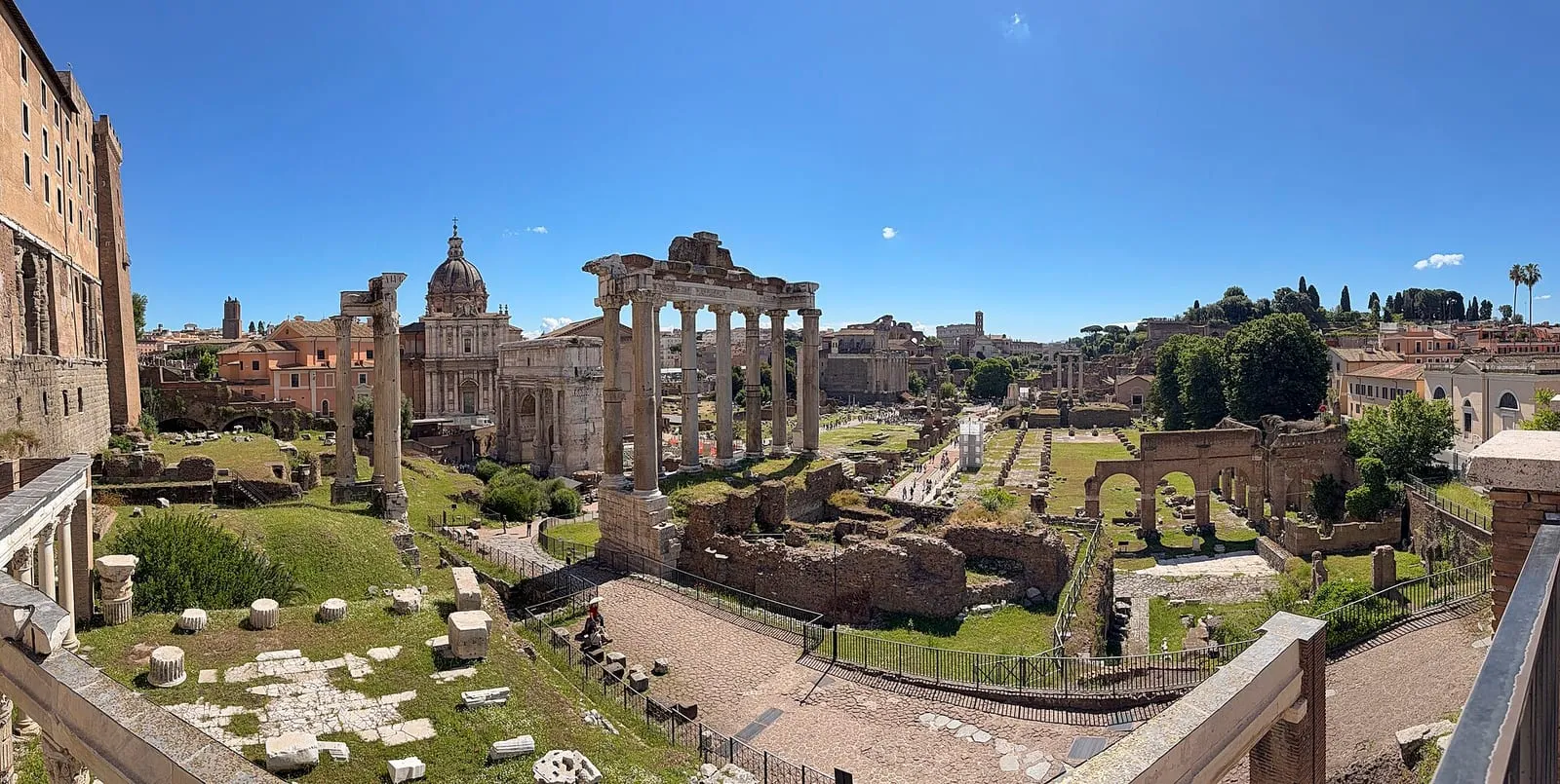 Vue plongeante sur le Forum romain depuis le Capitole : l'arc de Septime Sévère, le temple de Saturne et la basilique Julia au premier plan, le Palatin en arrière-plan