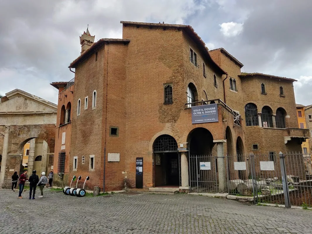 Maisons médiévales en brique au coin de la via del Portico d'Ottavia, avec l'arche du portique d'Octavie sur la gauche