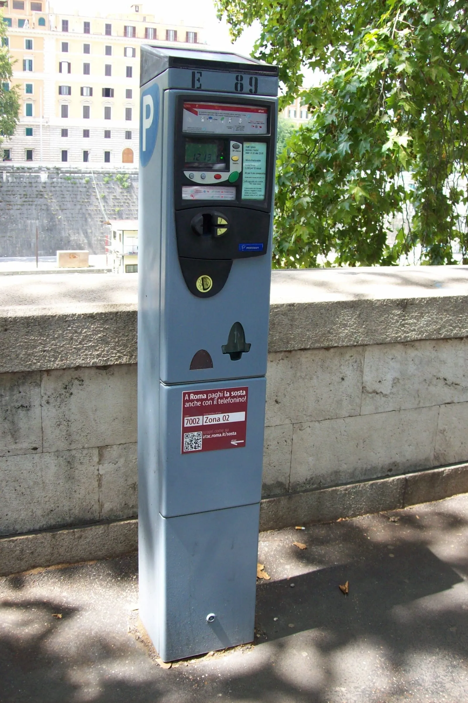 Horodateur de stationnement payant ATAC dans une rue de Rome, panneau bleu P et paiement possible par téléphone