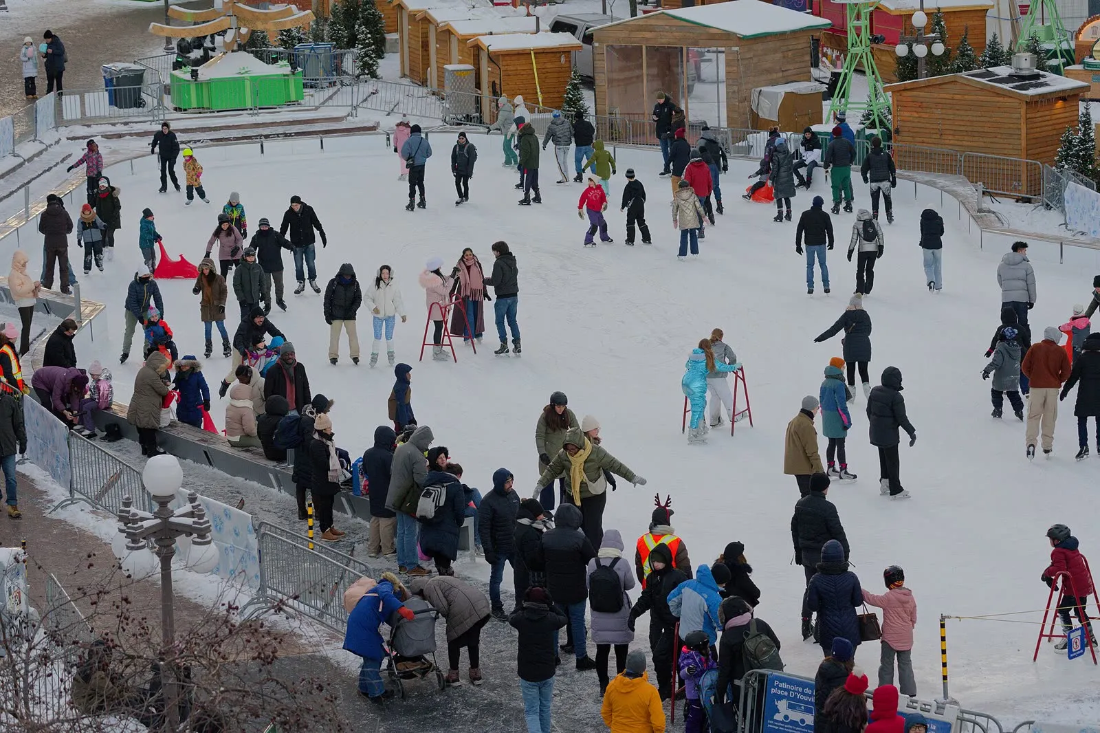 Patinoire de plein air sur une place urbaine, patineurs sur la glace au crépuscule