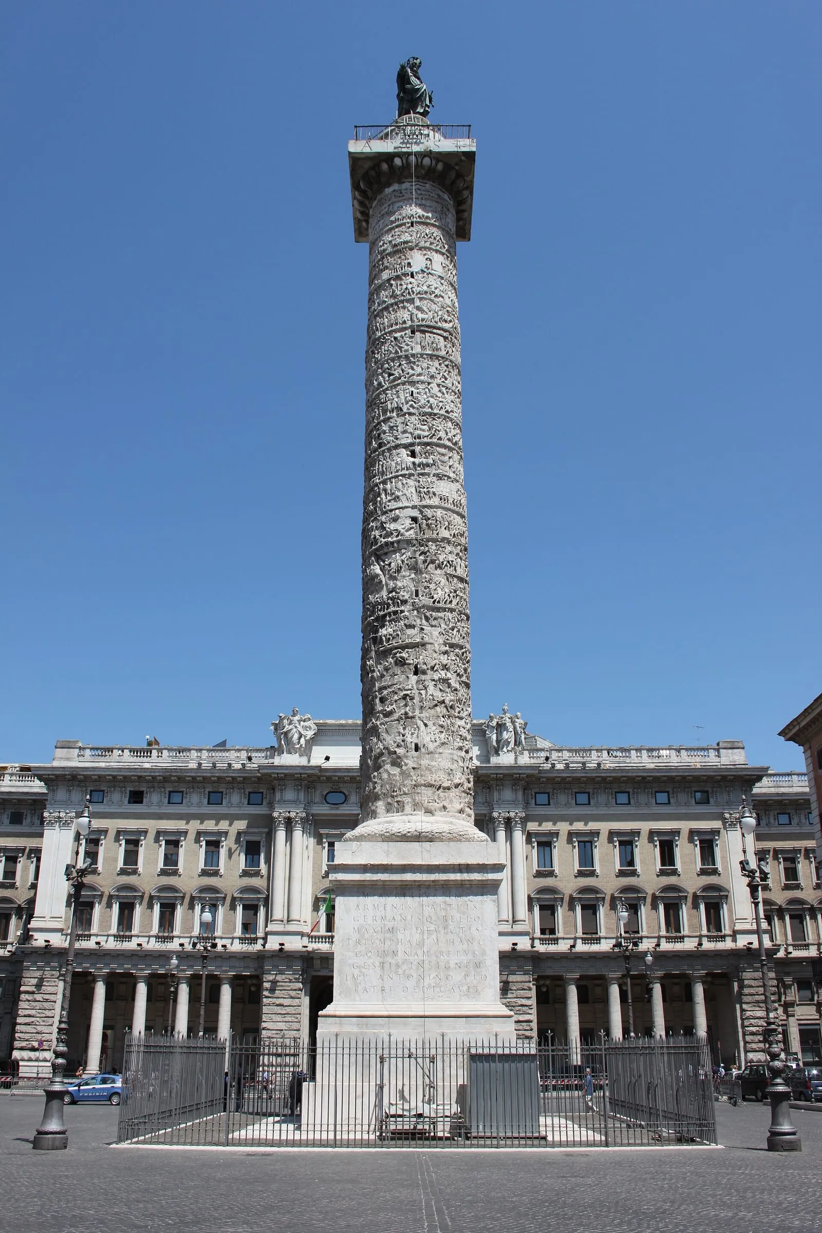 La colonne de Marc-Aurèle au centre de la piazza Colonna, son fût couvert de reliefs en spirale, sa statue de bronze au sommet et le palais Chigi en arrière-plan