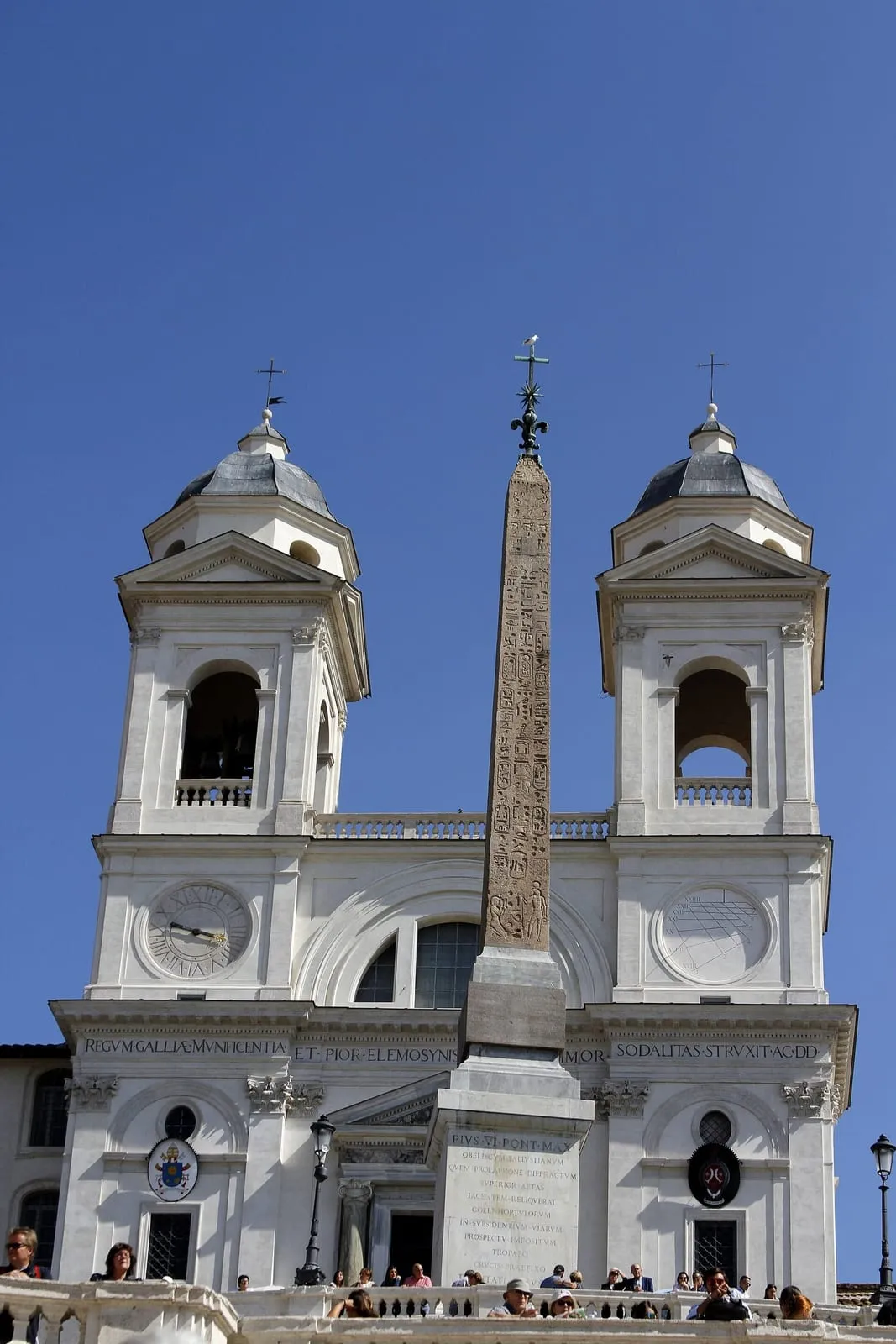 L'église Santissima Trinità dei Monti flanquée de ses deux clochers et l'obélisque Sallustiano surmonté d'une croix, vus depuis la terrasse au sommet de l'escalier de la place d'Espagne à Rome