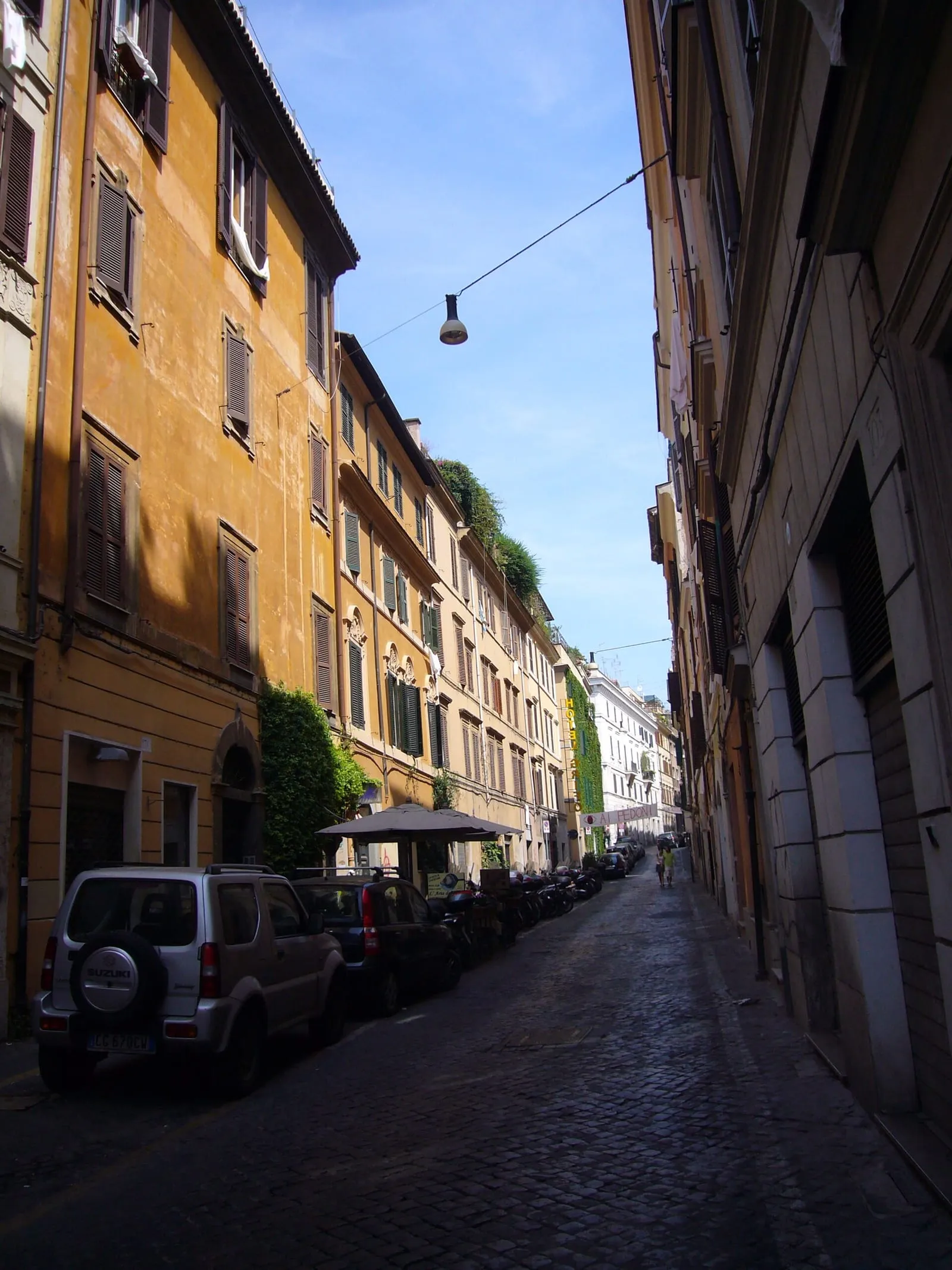 La via del Boschetto dans le rione Monti à Rome, rue pavée de sampietrini bordée de façades ocre et de volets verts