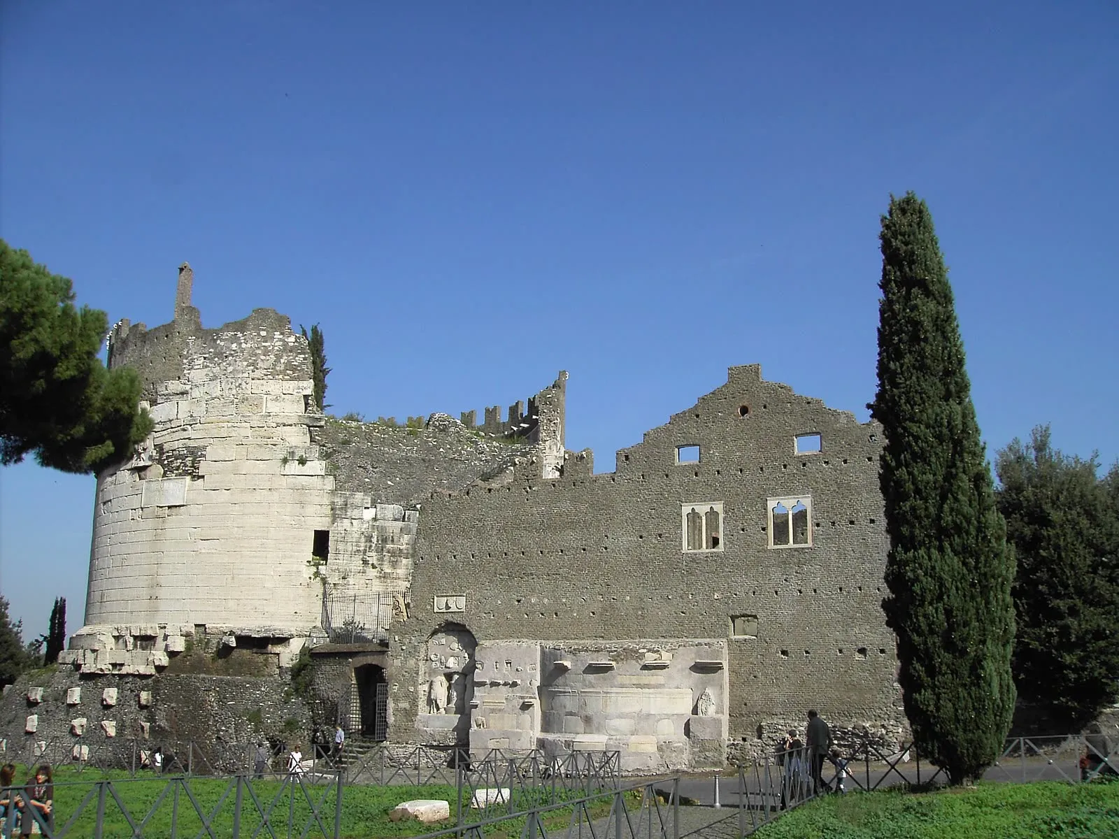 Le tombeau de Cecilia Metella sur la via Appia Antica, son tambour de travertin couronné d'une forteresse médiévale, derrière la barrière de la voie antique