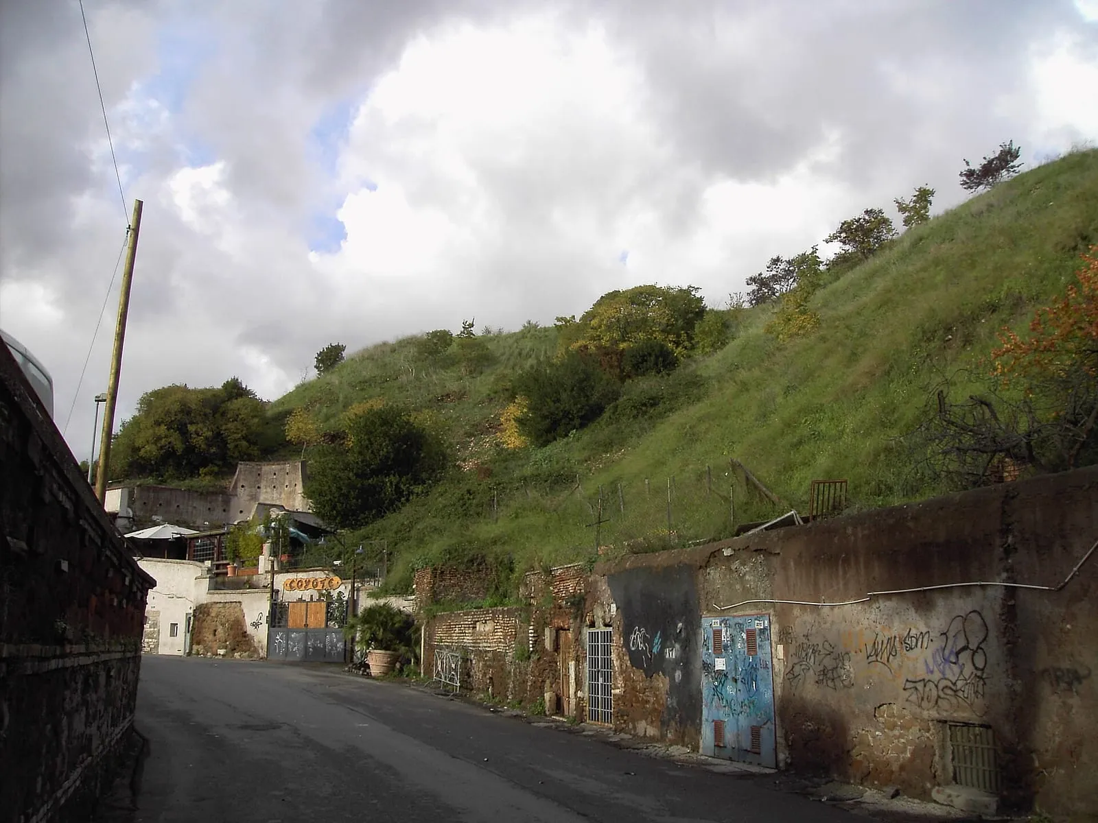 Le flanc herbeux du Monte Testaccio, au-dessus des portes et des murs tagués des caves creusées dans la colline de tessons d'amphores