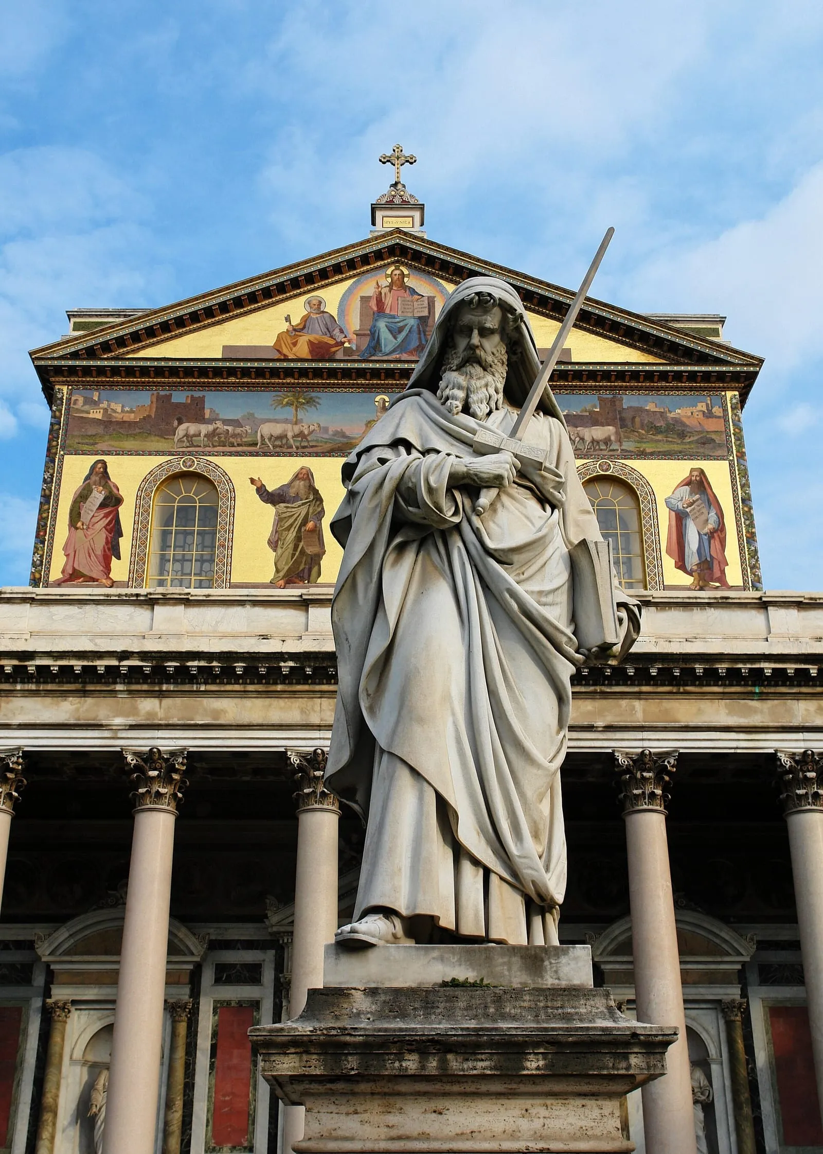 La façade mosaïquée de la basilique Saint-Paul-hors-les-Murs, dominée par la statue de saint Paul tenant son épée devant les colonnes du portique