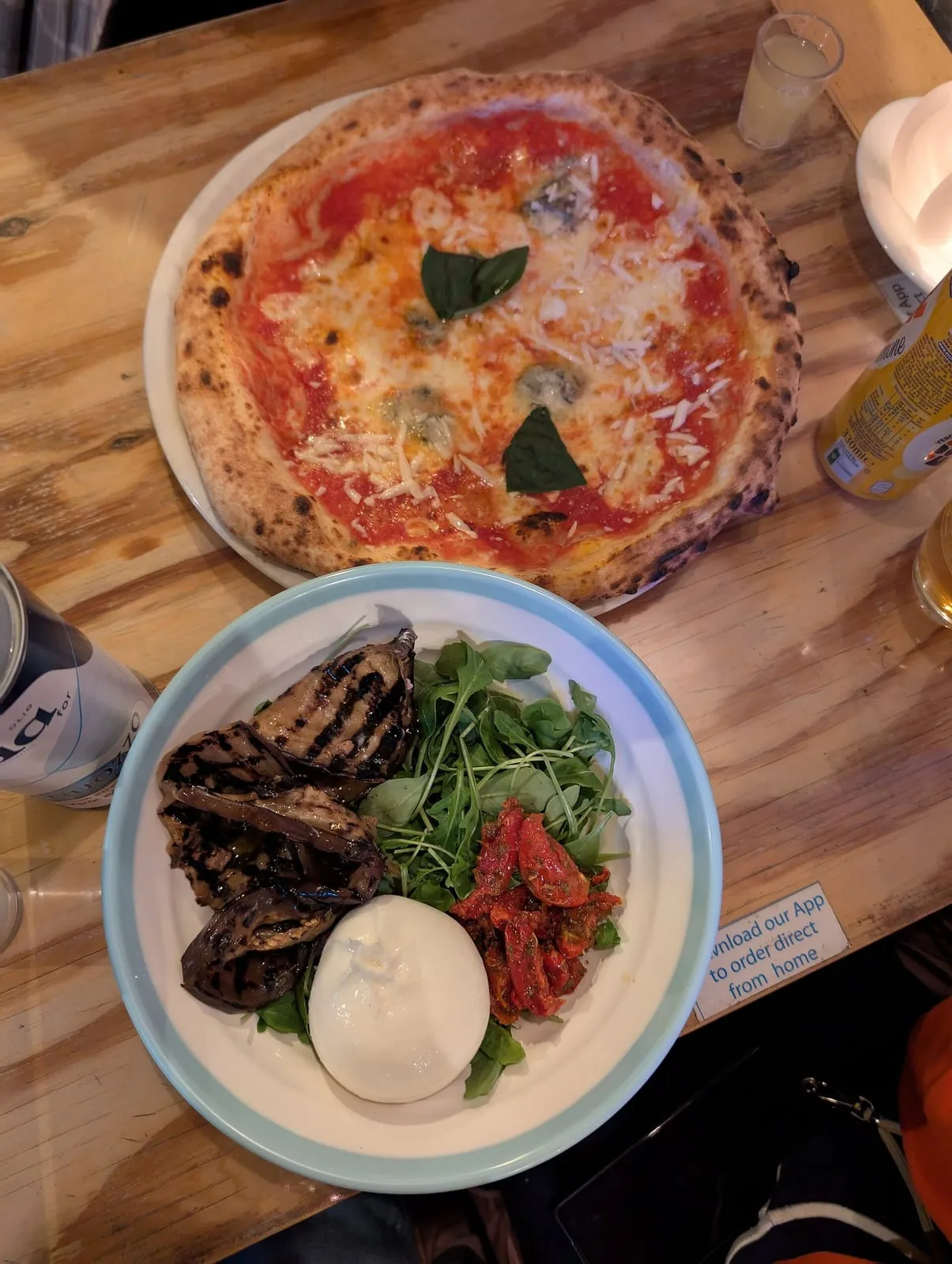 Salade à la burrata et pizza aux fromages servies sur une table de restaurant italien