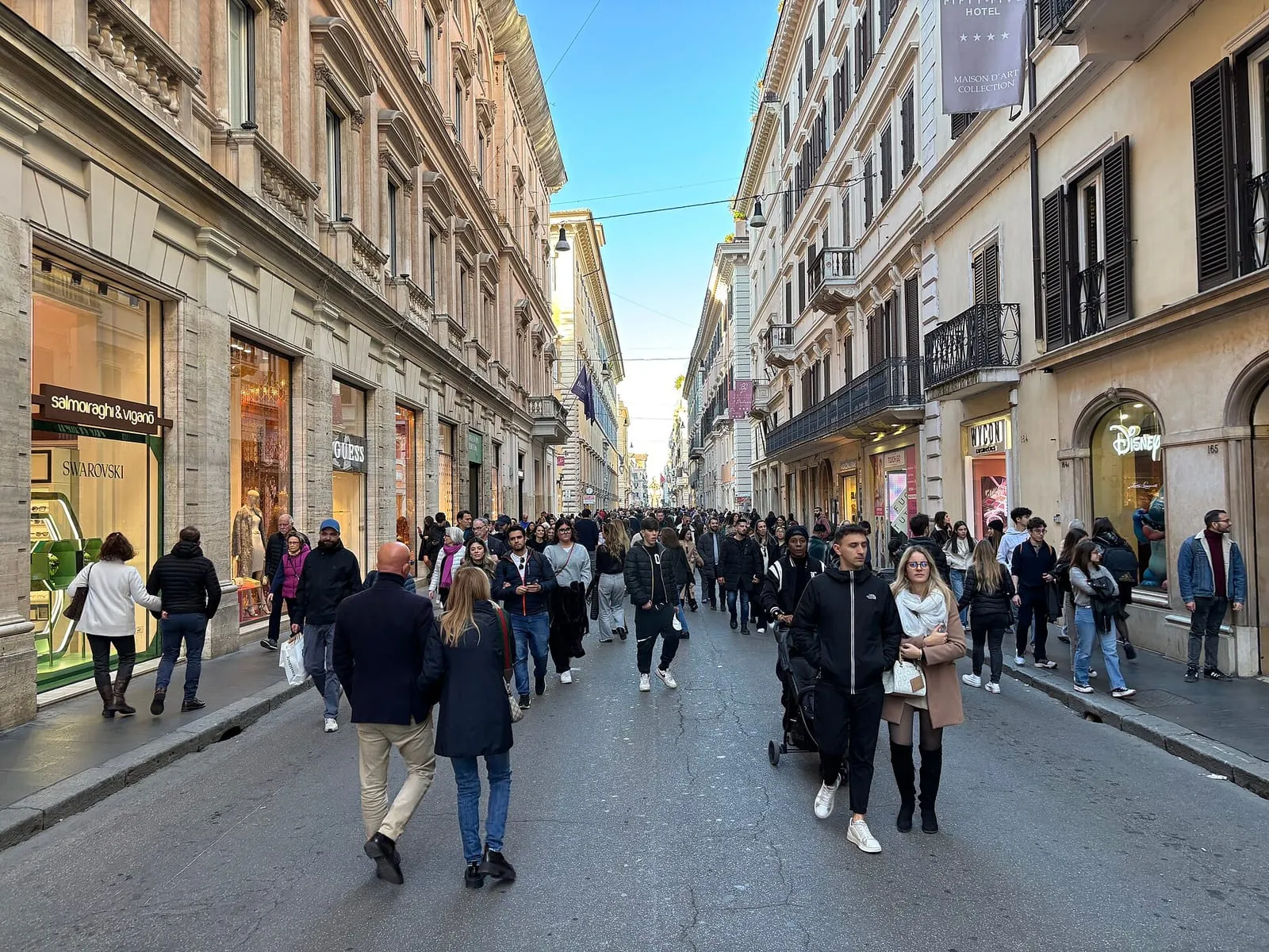 Foule du week-end dans la via del Corso à Rome, entre les vitrines