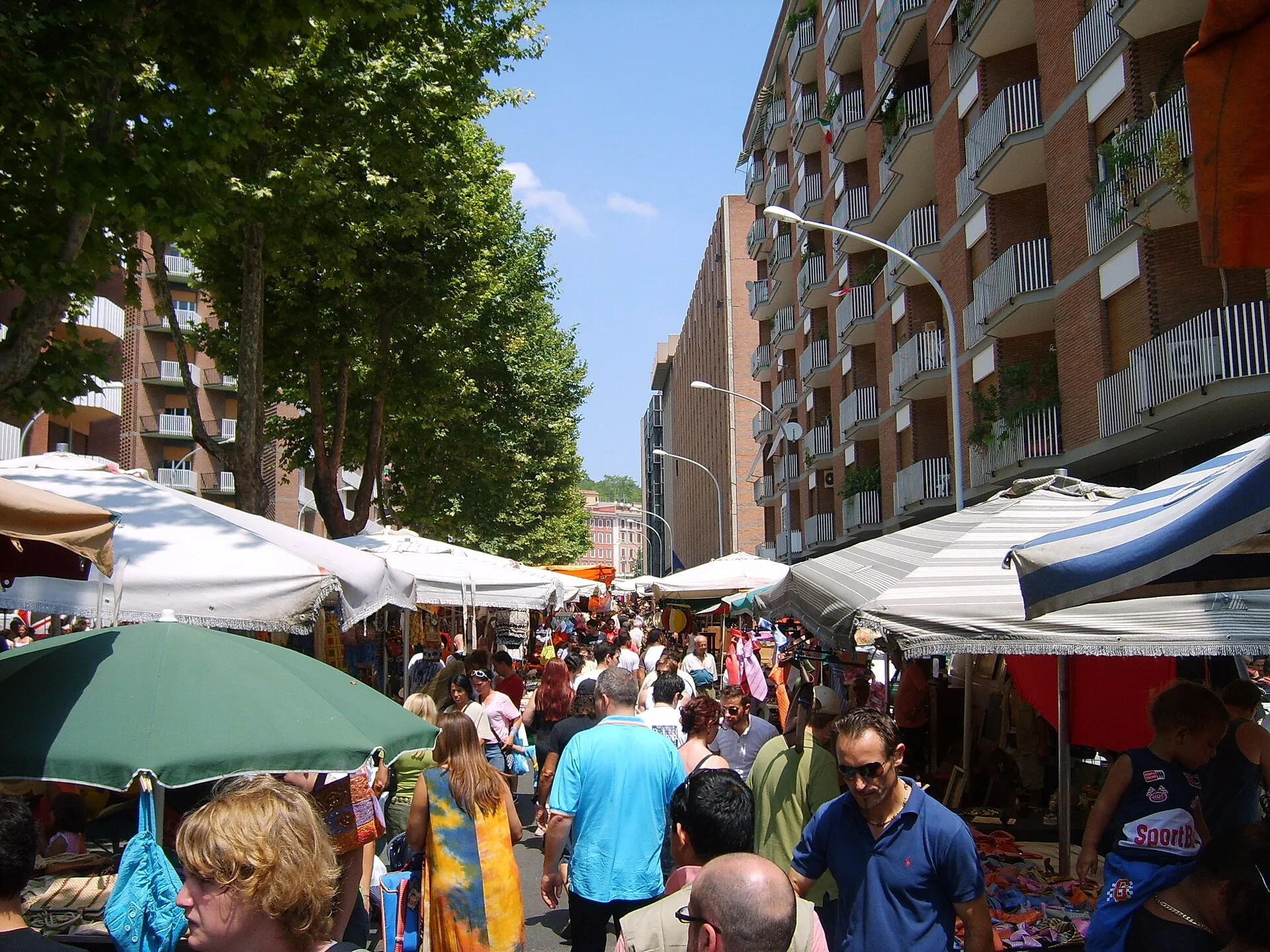 Foule de chineurs entre les étals du marché de Porta Portese un dimanche matin d'été