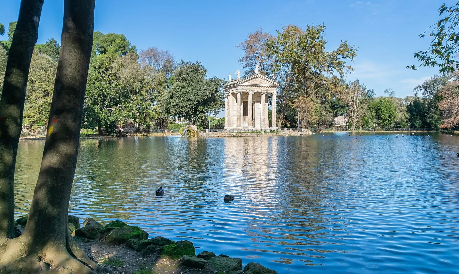 Le tempietto du Tempio di Esculapio sur son îlot au milieu du lac de la Villa Borghèse, entouré d'arbres